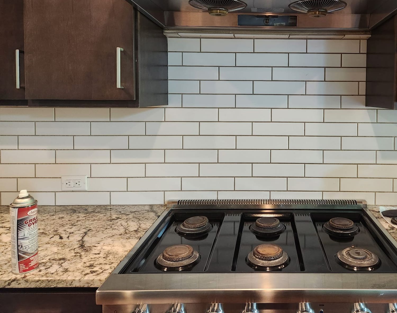 Professional cleaning products in use on a kitchen range by Elite Maid
